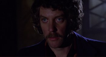 Movie still from “Don't Look Now” (1973), directed by Nicolas Roeg – A person with a beard; Close Up shot, Over the shoulder angle