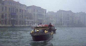 Movie still from “Don't Look Now” (1973), directed by Nicolas Roeg – A man in a boat on a body of water; Wide shot, High angle