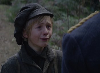 Movie still from “The Nightingale” (2018), directed by Jennifer Kent – A young boy wearing a hat and a jacket; Close Up shot, Over the shoulder angle