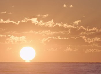 Movie still from “The Nightingale” (2018), directed by Jennifer Kent – The sun is setting over the ocean on a cloudy day; Extreme Wide shot, Low angle