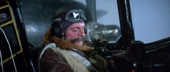 Movie still from “La Grande Vadrouille” (1966), directed by Gérard Oury – A man with a beard wearing a pilot's outfit; Medium shot, Low angle