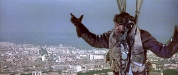 Movie still from “La Grande Vadrouille” (1966), directed by Gérard Oury – A man flying a plane over a large city; Medium shot, Low angle