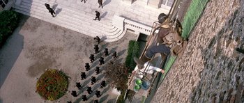 Movie still from “La Grande Vadrouille” (1966), directed by Gérard Oury – An aerial view of a group of people walking down a sidewalk; Extreme Wide shot, Overhead angle