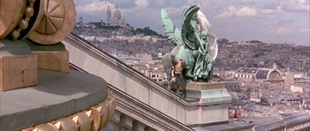 Movie still from “La Grande Vadrouille” (1966), directed by Gérard Oury – A statue of an angel on the top of a building; Extreme Wide shot, High angle