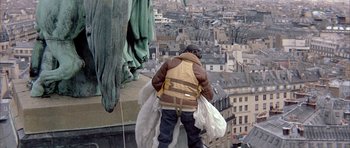 Movie still from “La Grande Vadrouille” (1966), directed by Gérard Oury – A man standing on the side of a building on the roof of a building; Wide shot, Low angle