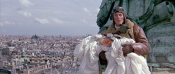 Movie still from “La Grande Vadrouille” (1966), directed by Gérard Oury – A man in a suit and goggles on top of a building; Medium shot, Overhead angle