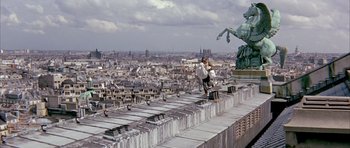 Movie still from “La Grande Vadrouille” (1966), directed by Gérard Oury – A man on a skateboard on a ledge above a city; Extreme Wide shot, High angle