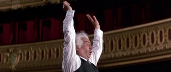 Movie still from “La Grande Vadrouille” (1966), directed by Gérard Oury – An older man in a white shirt and a black vest raising his hands; Medium shot, Low angle