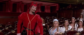 Movie still from “La Grande Vadrouille” (1966), directed by Gérard Oury – A man dressed as a devil standing next to a woman; Wide shot, Low angle
