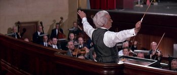 Movie still from “La Grande Vadrouille” (1966), directed by Gérard Oury – An older man in front of an audience with his arms outstreched; Medium shot, High angle