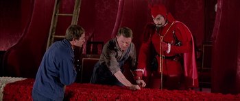 Movie still from “La Grande Vadrouille” (1966), directed by Gérard Oury – A group of people standing around a bed of red roses; Medium shot, High angle