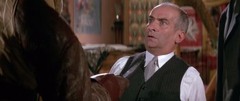 Movie still from “La Grande Vadrouille” (1966), directed by Gérard Oury – A man in a suit and tie holding a knife in his hand; Close Up shot, Over the shoulder angle