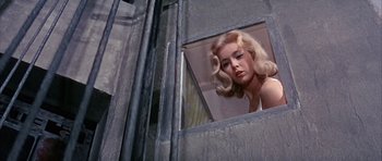 Movie still from “La Grande Vadrouille” (1966), directed by Gérard Oury – A woman with blonde hair looking out of a window; Close Up shot, Low angle