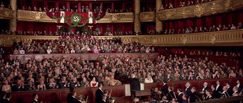 Movie still from “La Grande Vadrouille” (1966), directed by Gérard Oury – An audience is sitting in a large auditorium; Extreme Wide shot, High angle