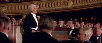 Movie still from “La Grande Vadrouille” (1966), directed by Gérard Oury – A man in a tuxedo is speaking to a group of people in front of him; Medium shot, High angle