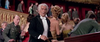 Movie still from “La Grande Vadrouille” (1966), directed by Gérard Oury – An older man in a tuxedo is holding a stick; Medium shot, Low angle