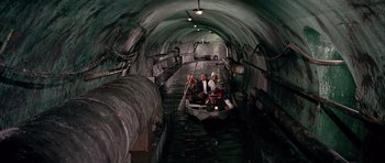 Movie still from “La Grande Vadrouille” (1966), directed by Gérard Oury – Three men are in a small boat in a tunnel; Wide shot, High angle