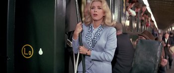 Movie still from “La Grande Vadrouille” (1966), directed by Gérard Oury – A woman in a blue suit holding a black and white polka dot umbrella; Medium shot, Low angle