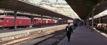 Movie still from “La Grande Vadrouille” (1966), directed by Gérard Oury – A man in a suit walking on a train platform; Extreme Wide shot, High angle