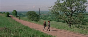Movie still from “La Grande Vadrouille” (1966), directed by Gérard Oury – Two men walking down a dirt road near a field; Extreme Wide shot, High angle
