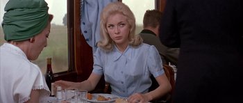 Movie still from “La Grande Vadrouille” (1966), directed by Gérard Oury – A woman sitting at a table with a plate in front of her; Medium shot, Over the shoulder angle