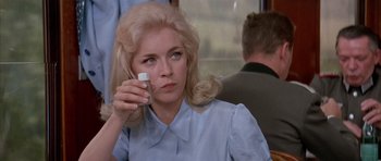 Movie still from “La Grande Vadrouille” (1966), directed by Gérard Oury – A woman holding a cell phone up to her face; Close Up shot, Over the shoulder angle