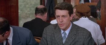 Movie still from “La Grande Vadrouille” (1966), directed by Gérard Oury – A person wearing a suit and tie; Close Up shot, Over the shoulder angle