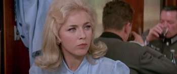 Movie still from “La Grande Vadrouille” (1966), directed by Gérard Oury – A woman with blonde hair sitting in front of a man; Close Up shot, Over the shoulder angle