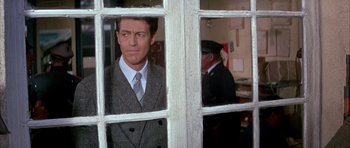 Movie still from “La Grande Vadrouille” (1966), directed by Gérard Oury – A man in a suit and tie looking out a window; Close Up shot, Over the shoulder angle