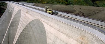 Movie still from “La Grande Vadrouille” (1966), directed by Gérard Oury – A semi truck driving on the side of a bridge; Extreme Wide shot, High angle