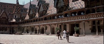 Movie still from “La Grande Vadrouille” (1966), directed by Gérard Oury – A group of people riding bikes in front of a building; Extreme Wide shot, High angle