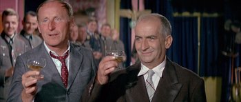 Movie still from “La Grande Vadrouille” (1966), directed by Gérard Oury – An older man holding a wine glass in front of a group of people; Close Up shot, Over the shoulder angle