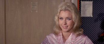 Movie still from “La Grande Vadrouille” (1966), directed by Gérard Oury – A woman with blonde hair and blue eyes wearing a pink shirt; Close Up shot, Over the shoulder angle