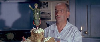 Movie still from “La Grande Vadrouille” (1966), directed by Gérard Oury – A man holding a knife in front of a cake; Medium shot, Low angle