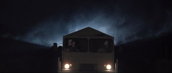 Movie still from “Doomsday” (2008), directed by Neil Marshall – A man sitting in the driver's seat of a bus at night; Wide shot, Low angle