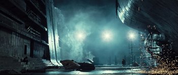 Movie still from “Doomsday” (2008), directed by Neil Marshall – A man standing in front of a building at night; Extreme Wide shot, Low angle