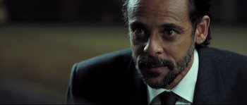 Movie still from “Doomsday” (2008), directed by Neil Marshall – A person wearing a suit and tie; Close Up shot, Over the shoulder angle