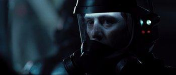 Movie still from “Doomsday” (2008), directed by Neil Marshall – A man wearing a gas mask in a dark room; Close Up shot, Over the shoulder angle
