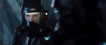Movie still from “Doomsday” (2008), directed by Neil Marshall – A person wearing a helmet; Close Up shot, Over the shoulder angle