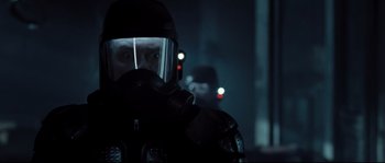 Movie still from “Doomsday” (2008), directed by Neil Marshall – A man wearing a gas mask in the dark; Close Up shot, Over the shoulder angle