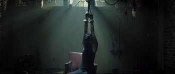 Movie still from “Doomsday” (2008), directed by Neil Marshall – A woman is chained to a chair in a room; Wide shot, Low angle