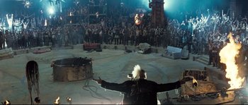 Movie still from “Doomsday” (2008), directed by Neil Marshall – A crowd of people standing in front of a stage; Extreme Wide shot, High angle