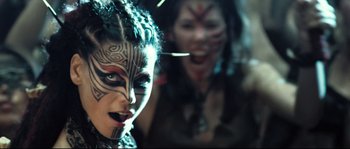 Movie still from “Doomsday” (2008), directed by Neil Marshall – Two women with face tattoos and piercings are posing for the camera; Close Up shot, Overhead angle
