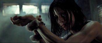 Movie still from “Doomsday” (2008), directed by Neil Marshall – A woman is holding a pair of handcuffs in her hands; Close Up shot, Low angle
