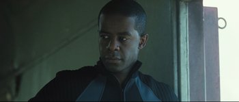 Movie still from “Doomsday” (2008), directed by Neil Marshall – A person wearing a black and blue jacket; Close Up shot, Low angle