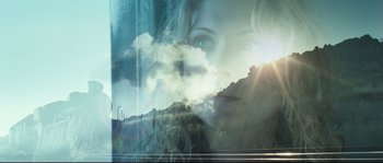 Movie still from “Doomsday” (2008), directed by Neil Marshall – A double exposure of a woman's face and mountains; Extreme Close Up shot, Low angle