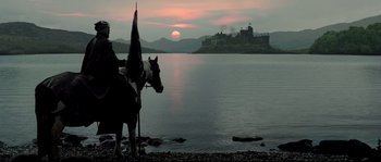 Movie still from “Doomsday” (2008), directed by Neil Marshall – A person on a horse near a body of water; Extreme Wide shot, Low angle