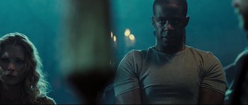 Movie still from “Doomsday” (2008), directed by Neil Marshall – A person sitting in a room; Close Up shot, Low angle