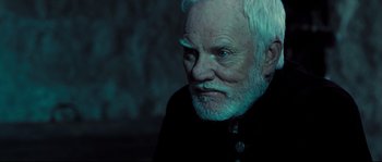 Movie still from “Doomsday” (2008), directed by Neil Marshall – An old man with a white beard is looking at the camera; Close Up shot, Over the shoulder angle