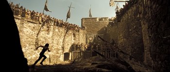 Movie still from “Doomsday” (2008), directed by Neil Marshall – A group of people standing on top of a stone wall; Extreme Wide shot, Low angle